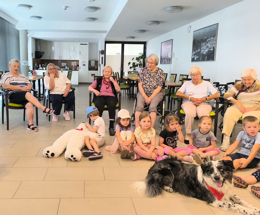 Bewohner und Kitakinder mit Therapiehund Jimmy