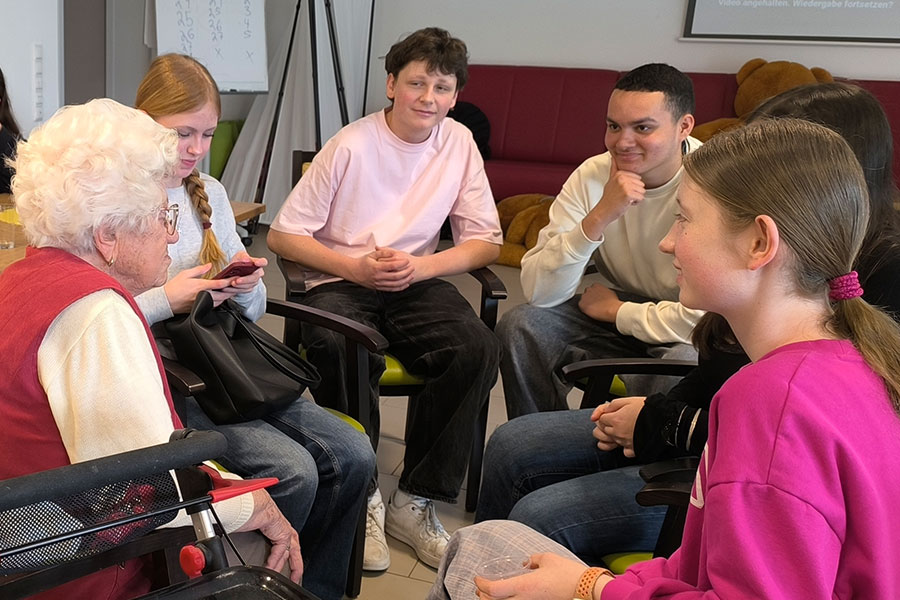 „Jung und Alt“ tauschten Erfahrungen aus: Gruppe mit Konfirmanden hört einer Seniorin aufmerksam zu